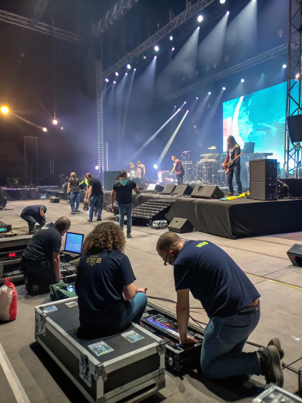 A picture of volunteers setting up the stage and sound equipment for a community concert, demonstrating the logistical support provided by the association.